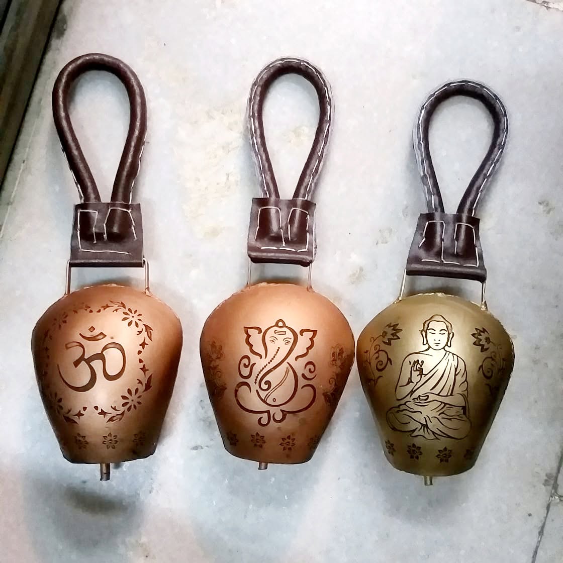 Hand-engraved cow bells with Om, Ganesha and Buddha designs